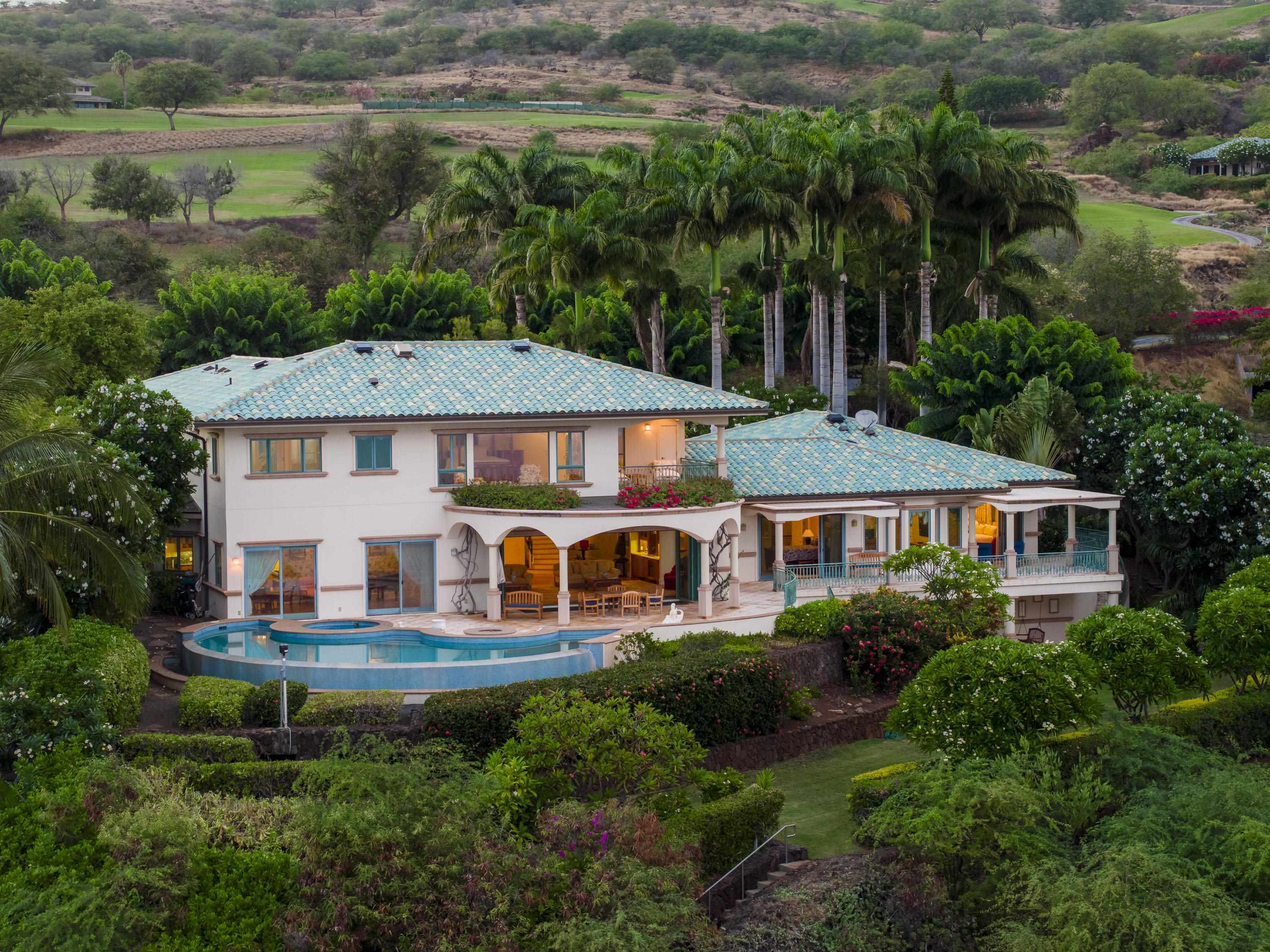 an aerial view of a house with a garden and lake view