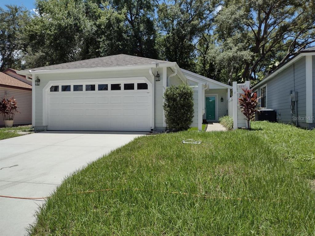 a front view of house with yard and trees in the background