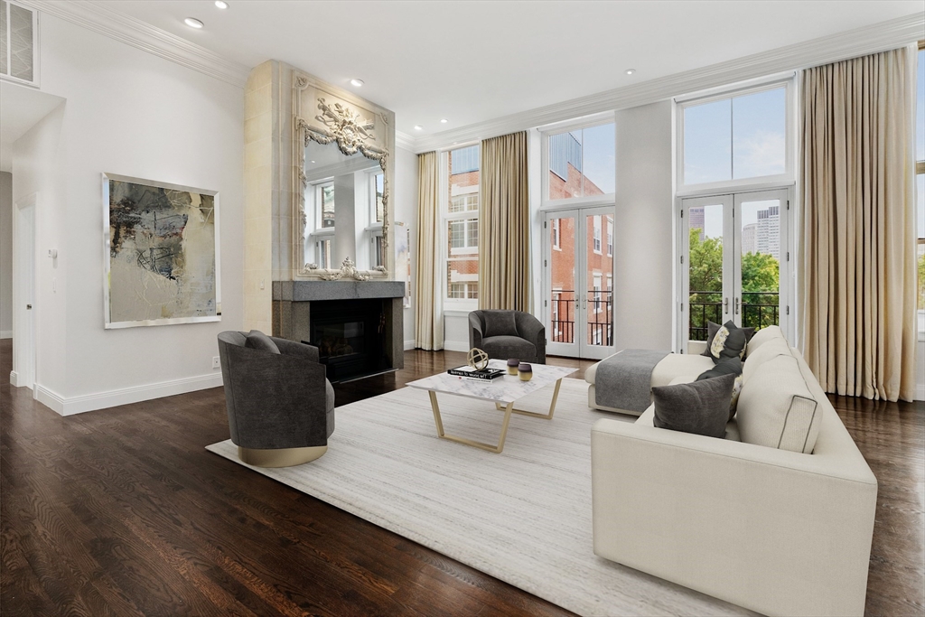 a living room with furniture large window and wooden floor