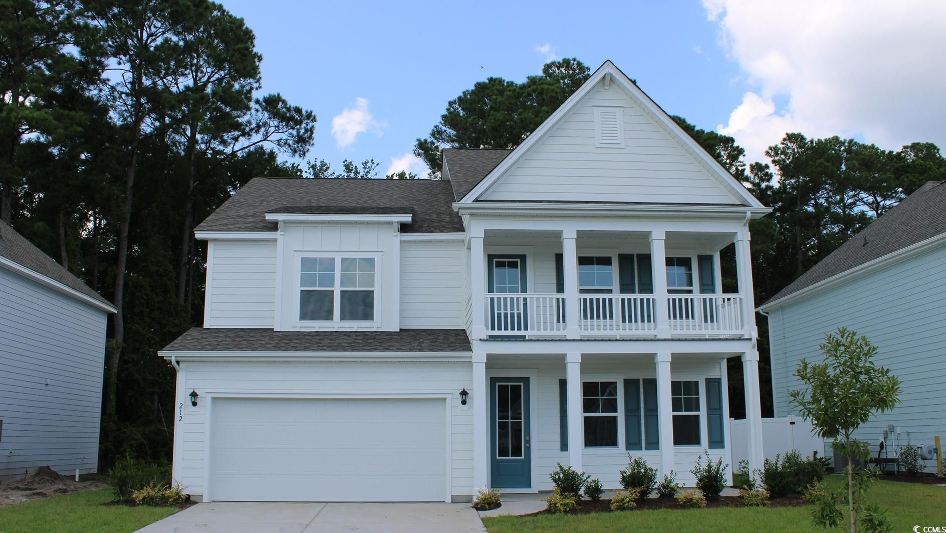 View of front of home featuring a balcony and a ga