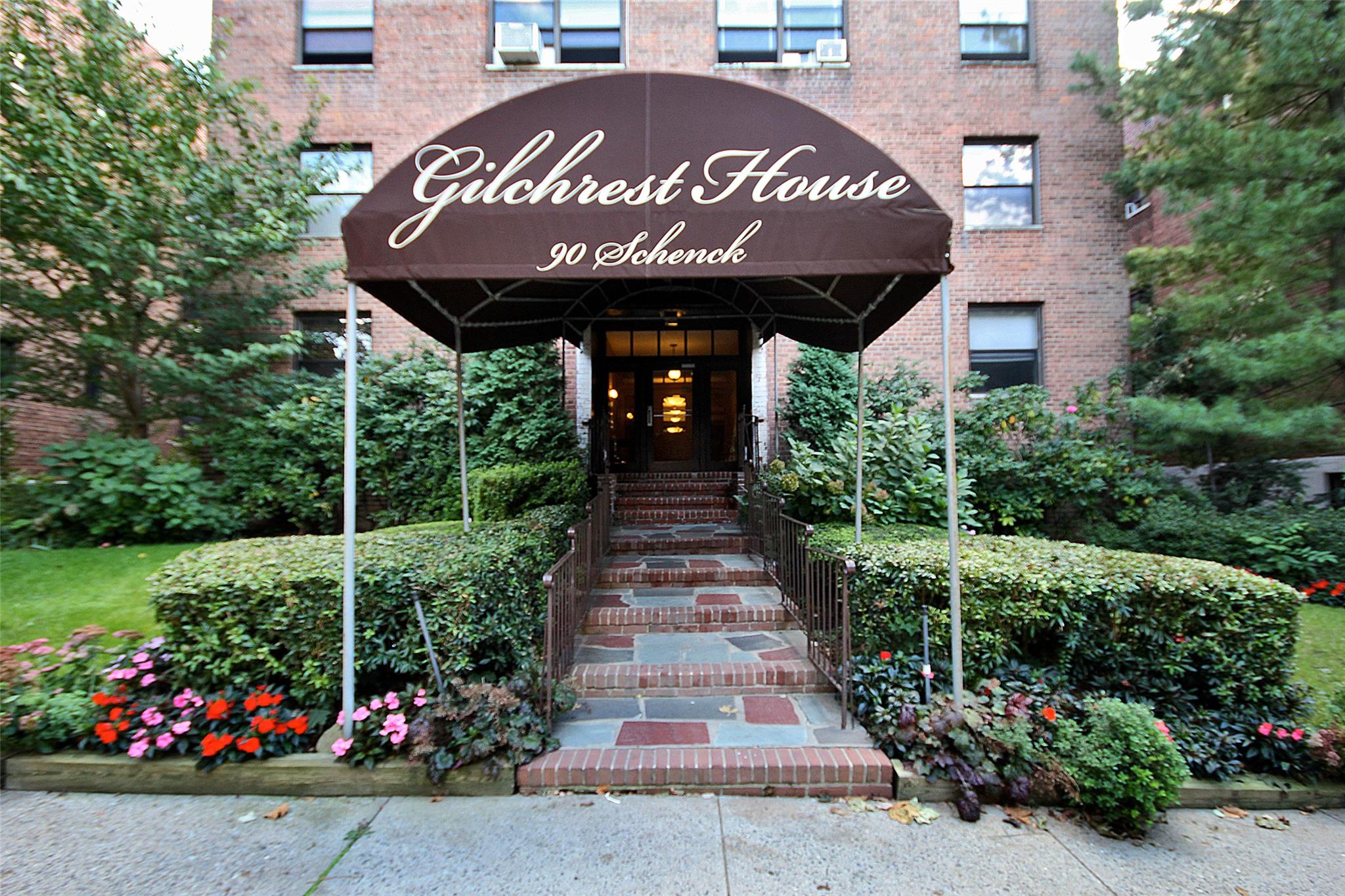 a front view of multi story residential apartment building with yard and sign board