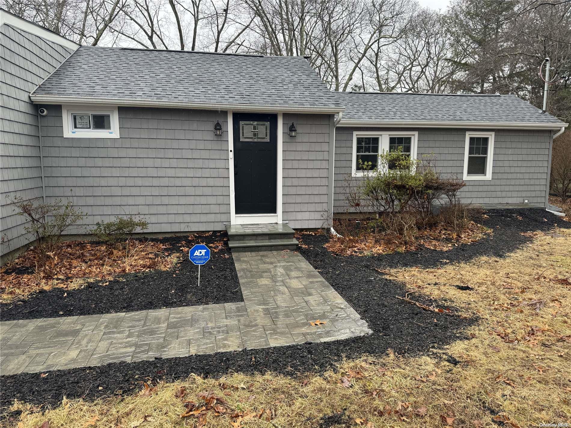 a front view of house with yard and trees around