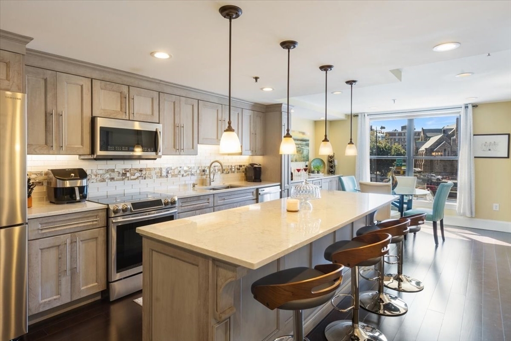 a kitchen with a stove a counter top space appliances and a center island