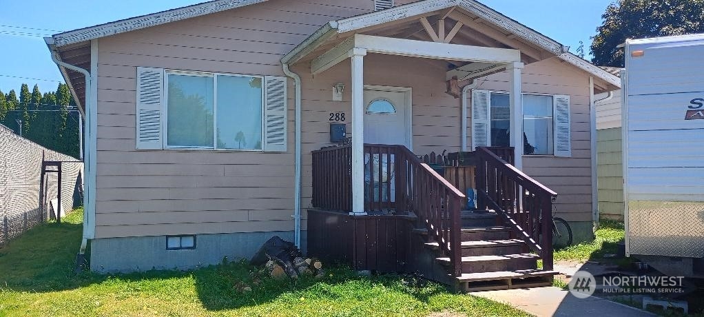 a view of a house with a small yard and wooden floor and fence