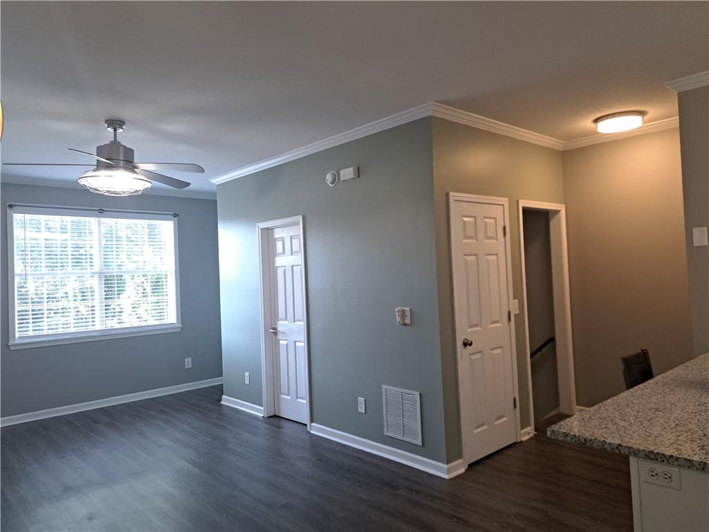 a view of an empty room with window and wooden floor