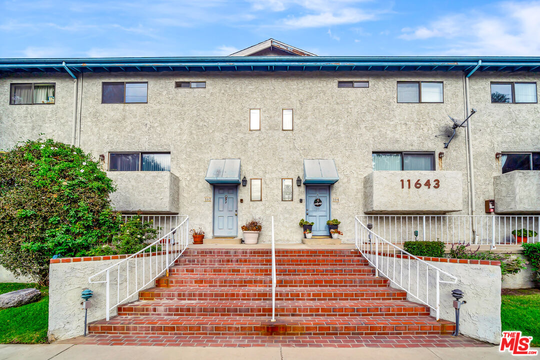 a front view of a building with a garden