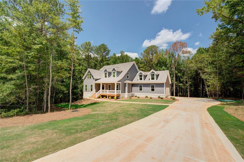 a front view of a house with a yard and trees