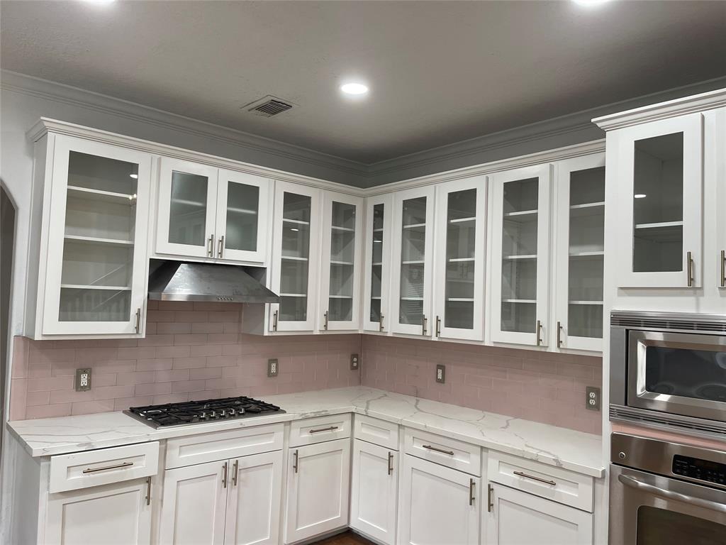 a kitchen with stainless steel appliances kitchen island a stove and a sink