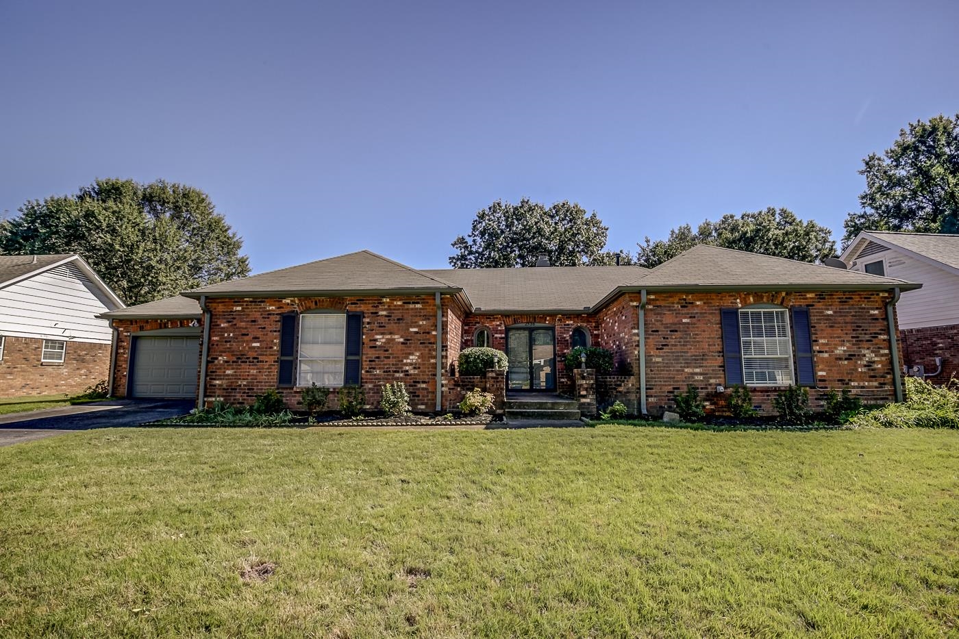 Ranch-style home featuring a front lawn and a garage