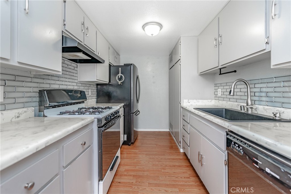 a kitchen with stainless steel appliances granite countertop a sink and a stove