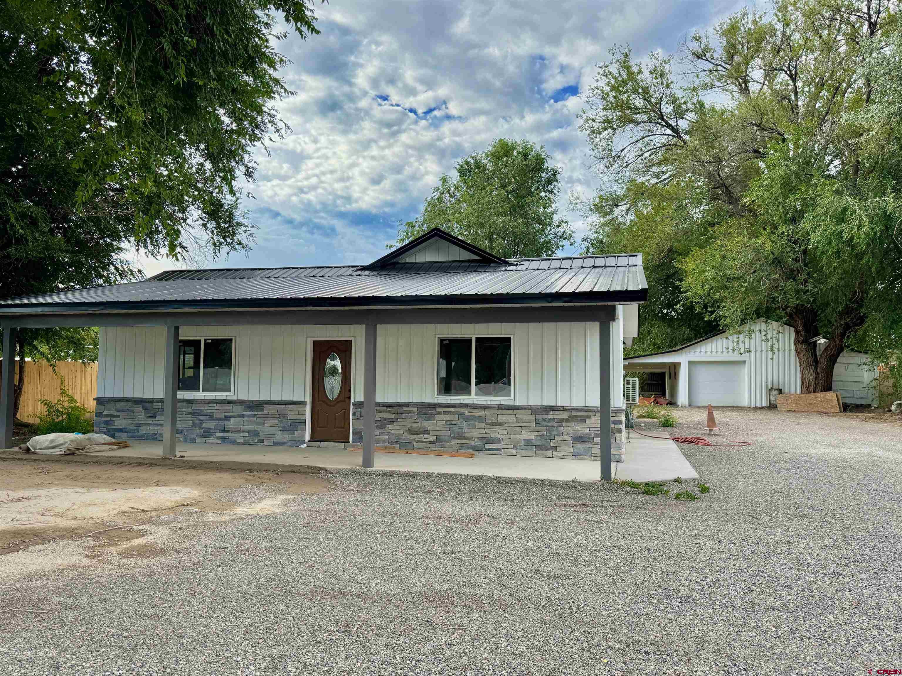 a front view of a house with yard and parking