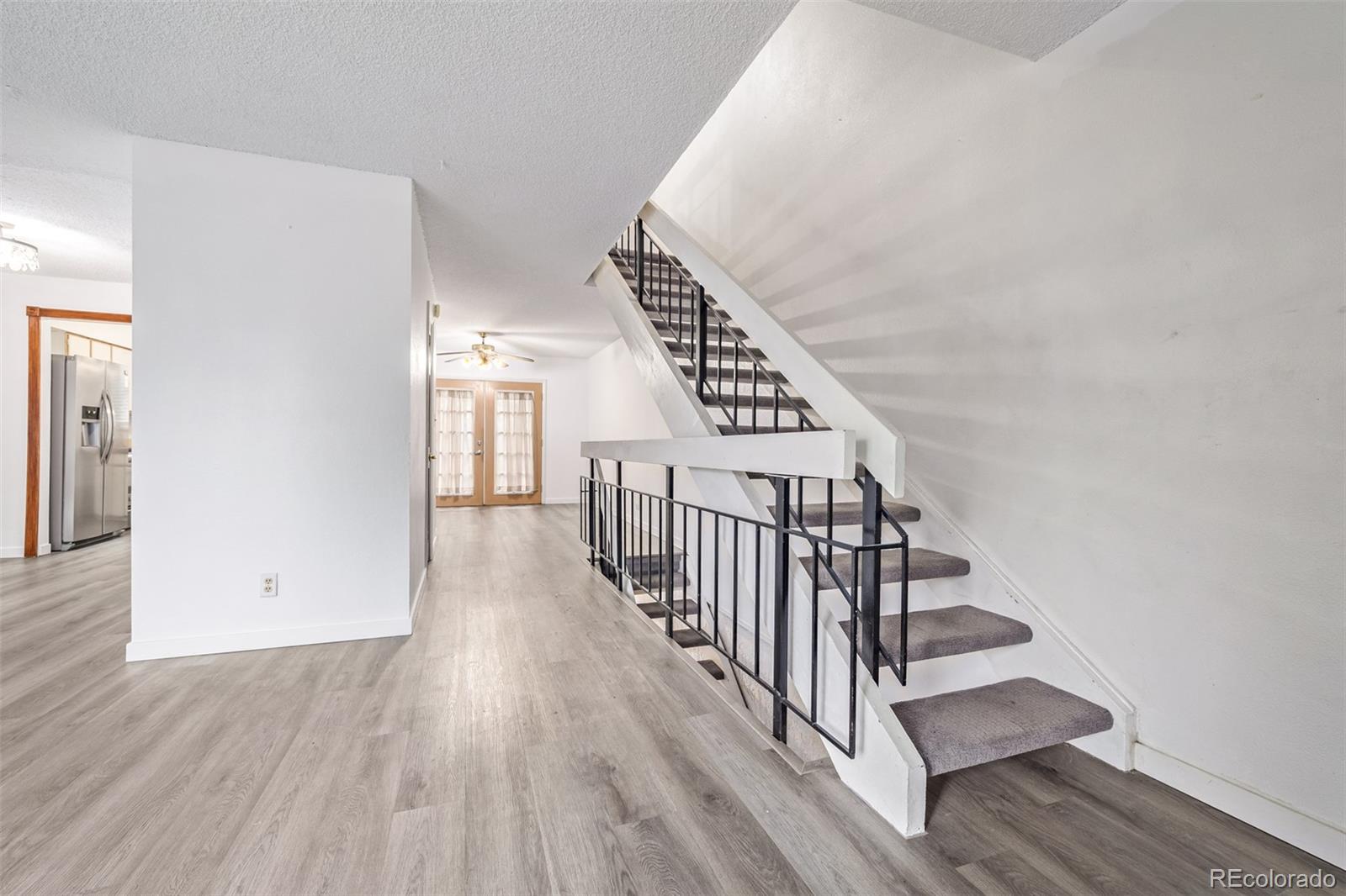 a view of a hallway with wooden floor and stairs