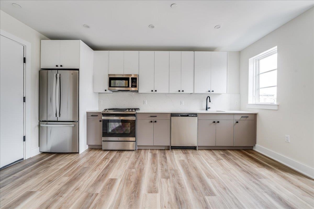 a kitchen with a refrigerator and a stove top oven