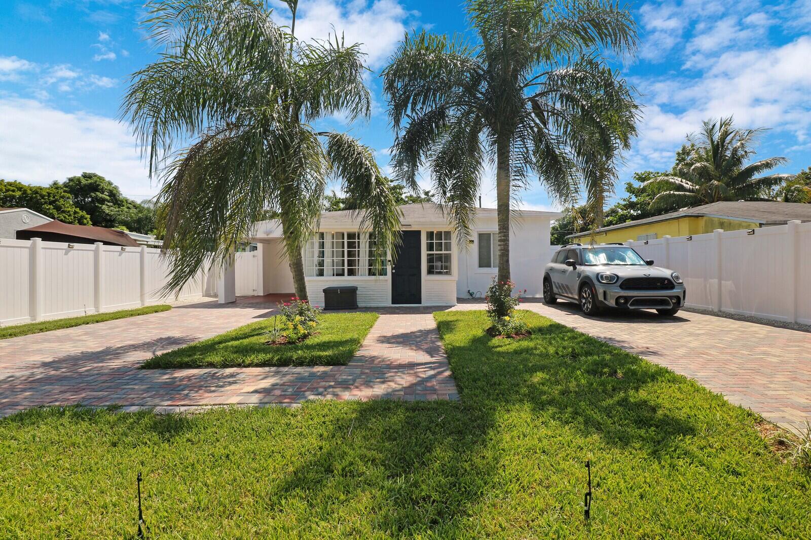 a house with a garden and palm trees