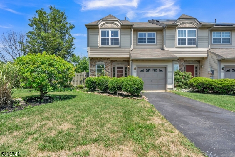 a front view of a house with a yard and trees