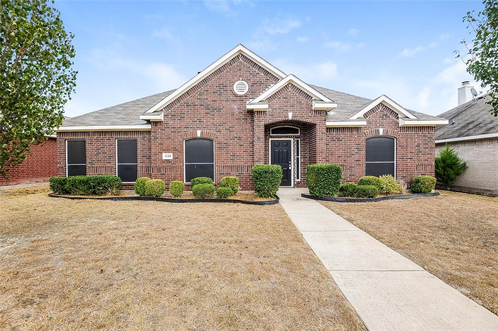 front view of a brick house with a yard