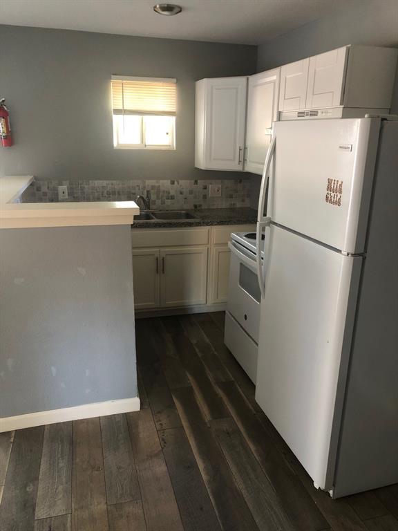 a kitchen with a sink a refrigerator and window