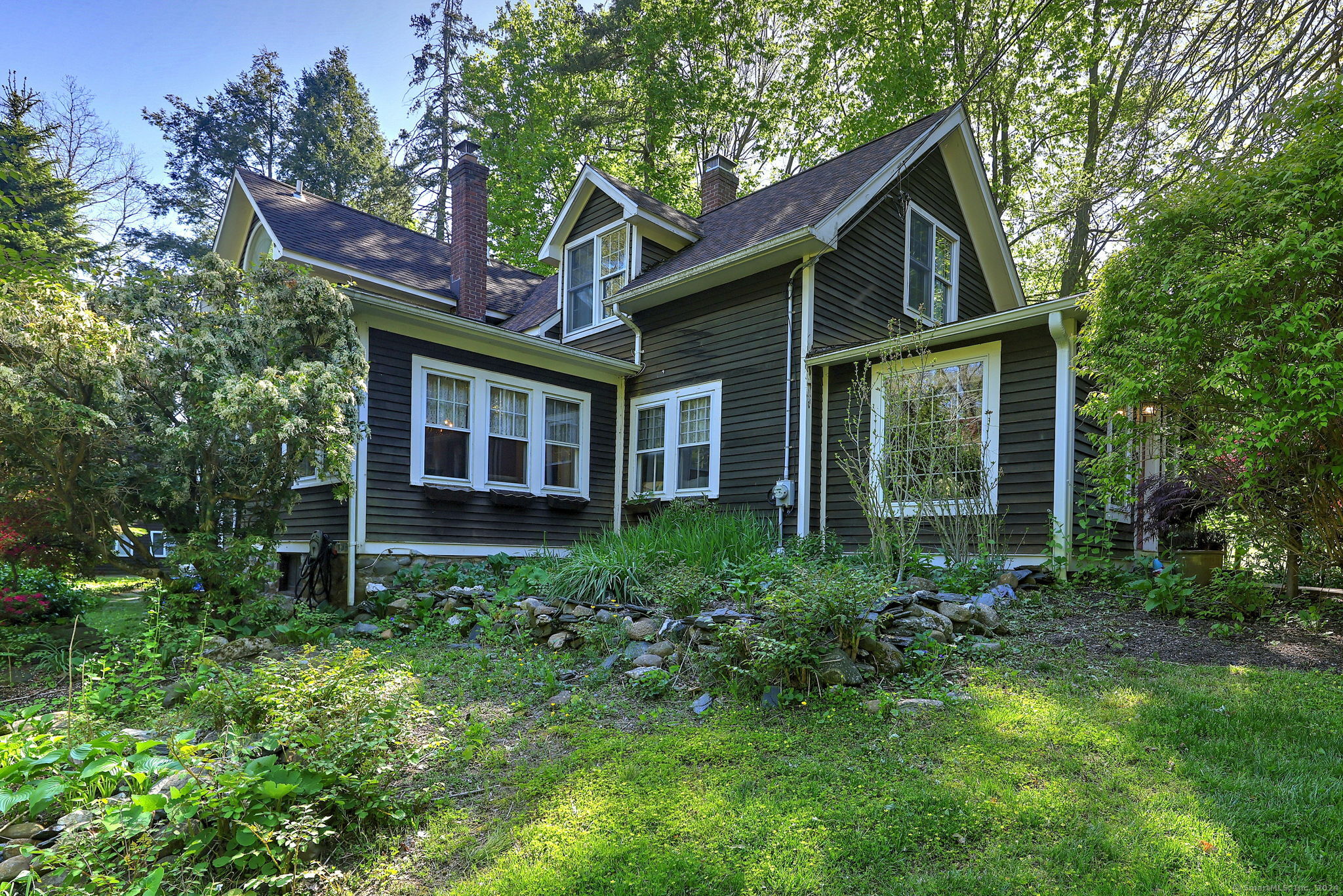 a view of brick house with a yard and potted plants