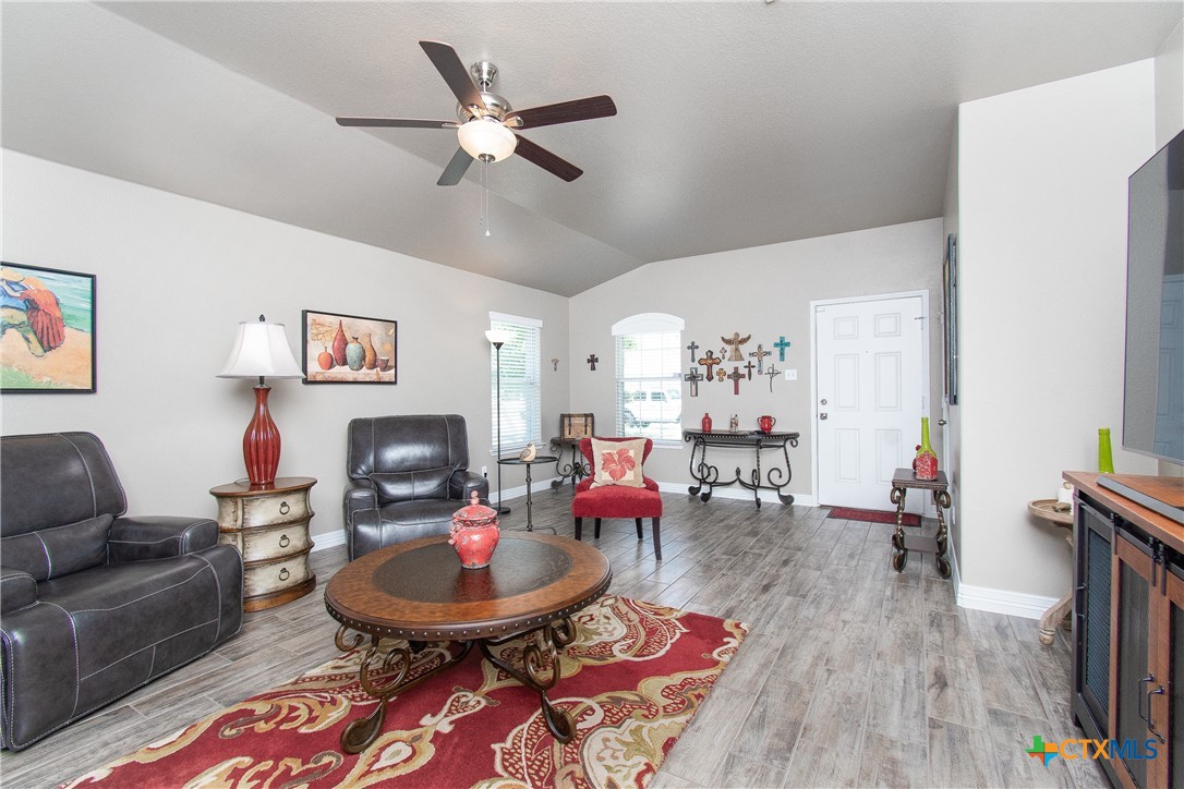 a living room with furniture and a wooden floor