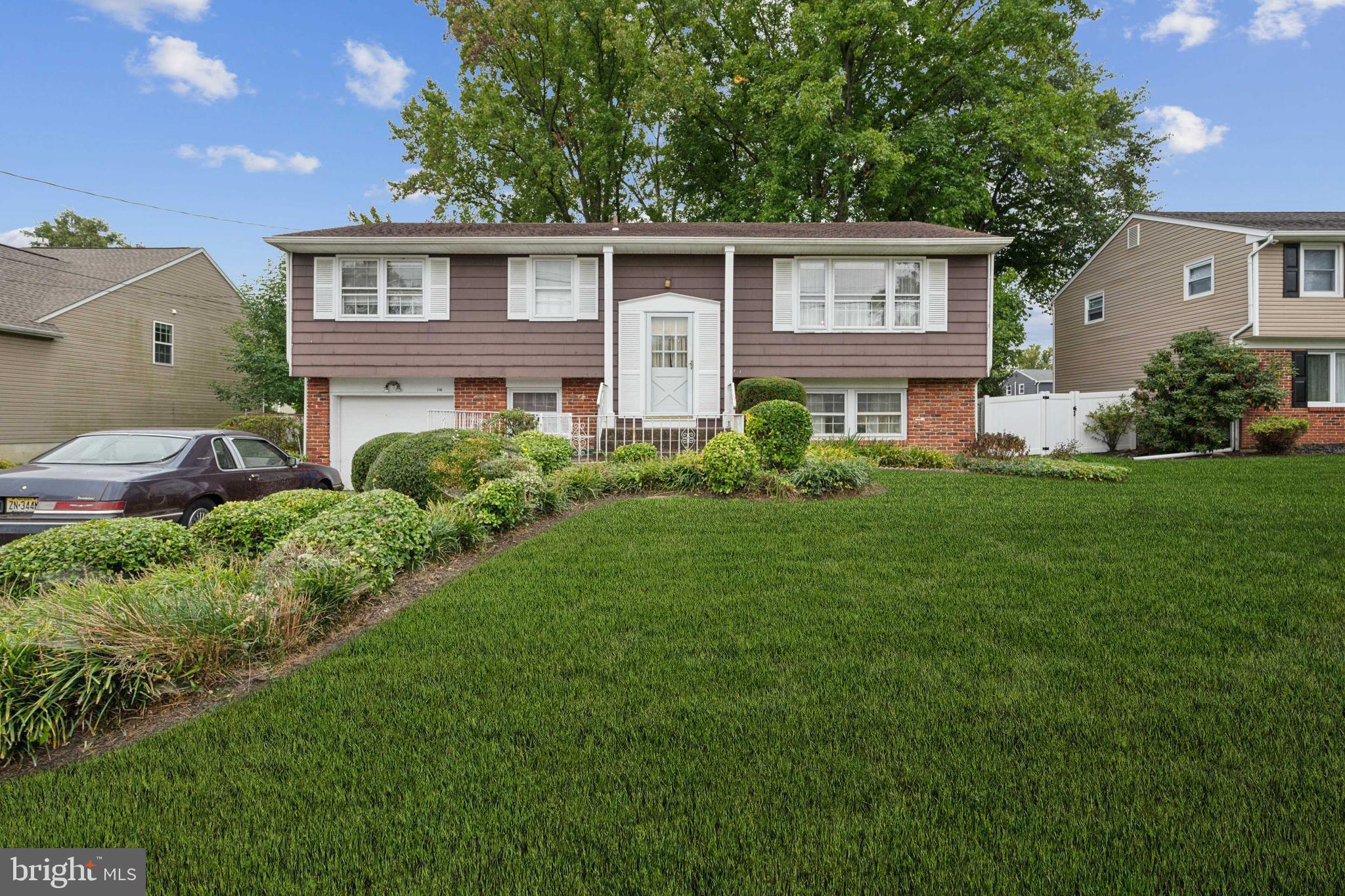 a front view of a house with a yard and trees