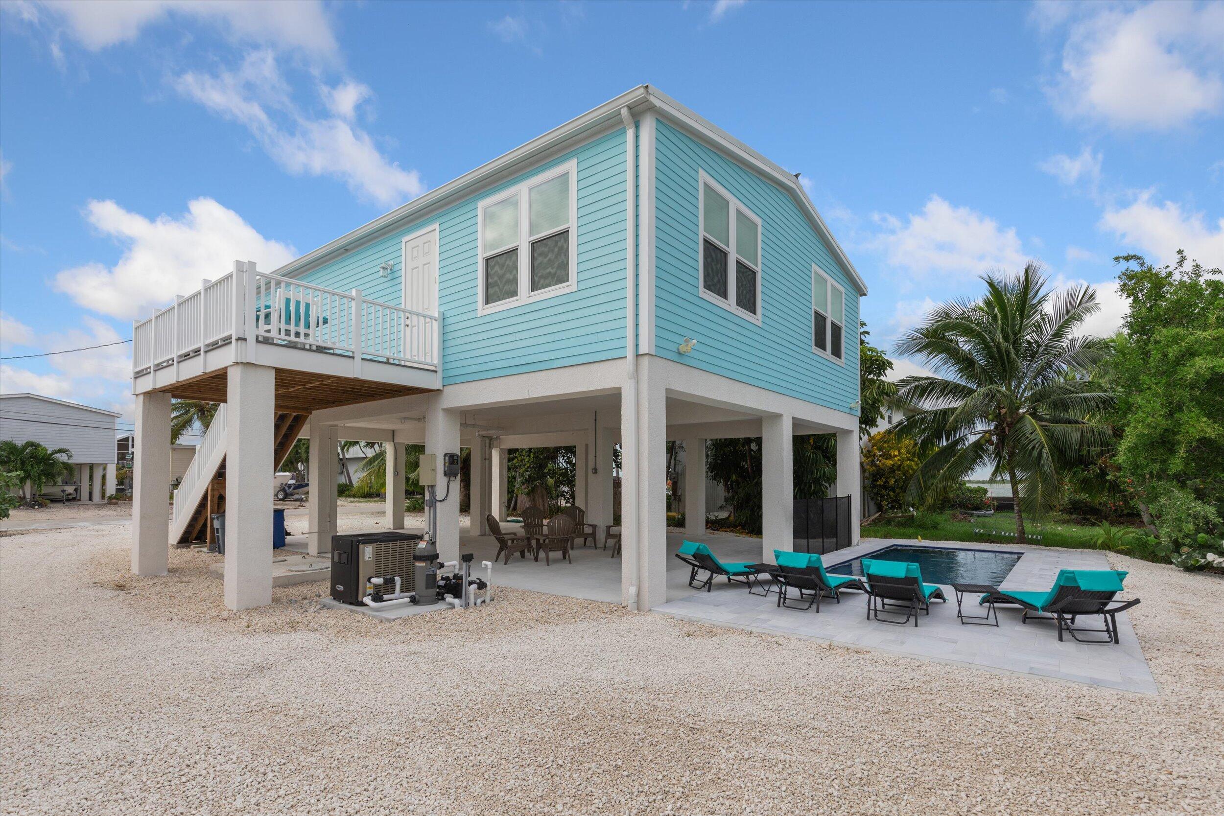 a view of a house with a patio and a yard