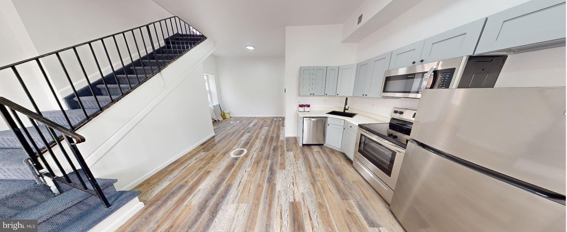 a view of a kitchen with stainless steel appliances wooden floor and electronic appliances