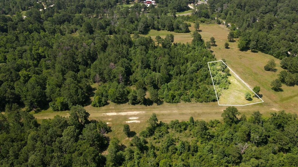 an aerial view of residential house with outdoor space and trees all around