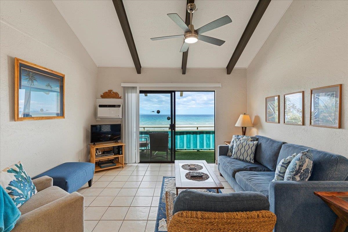 a living room with furniture a flat screen tv and a floor to ceiling window