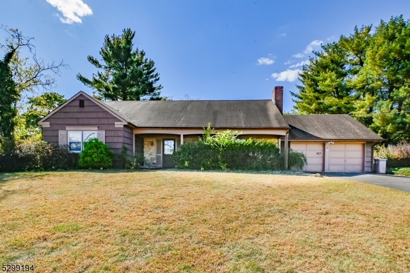 a front view of a house with a yard and potted plants