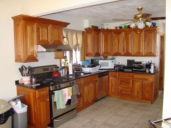 a kitchen with stainless steel appliances a stove a sink dishwasher and cabinets with wooden floor