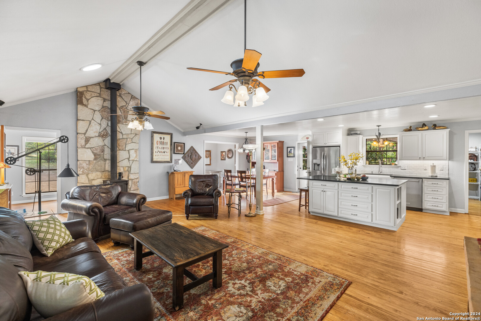 a living room with furniture kitchen view and a chandelier