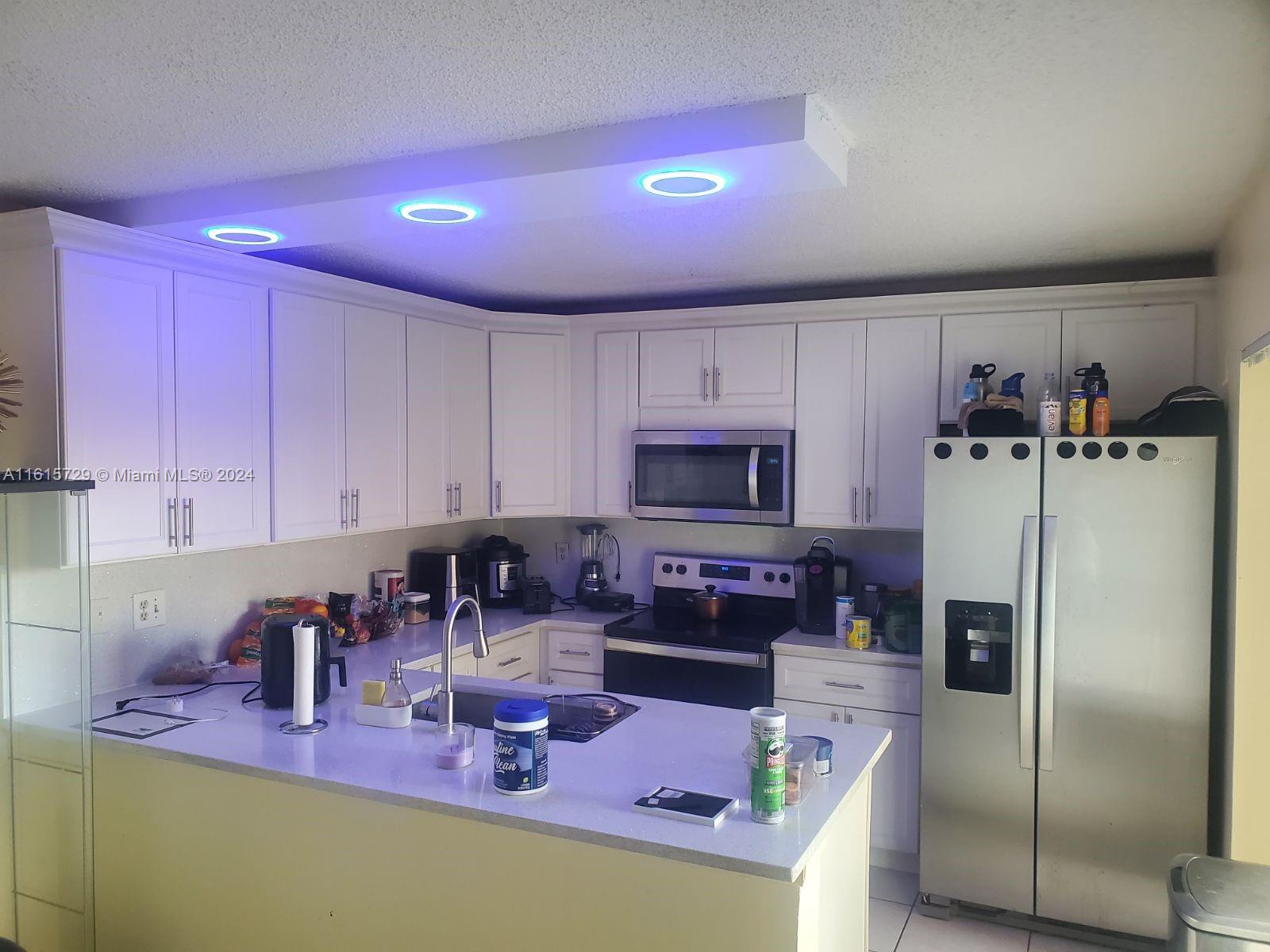 a kitchen with granite countertop a refrigerator stove top oven and sink