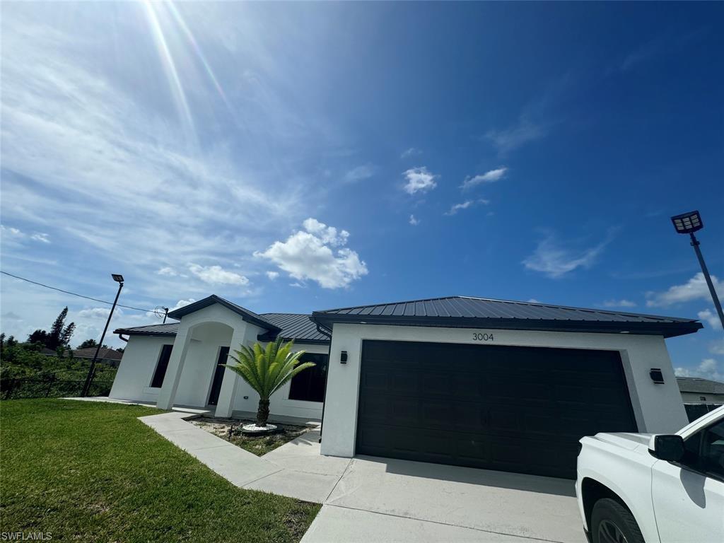 View of front of property featuring a garage and a front yard