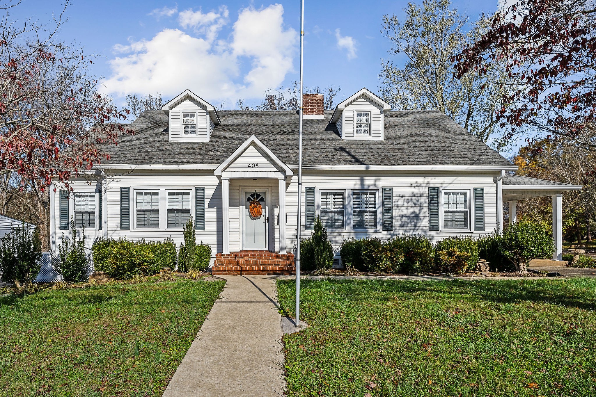 a front view of a house with a yard and potted plants