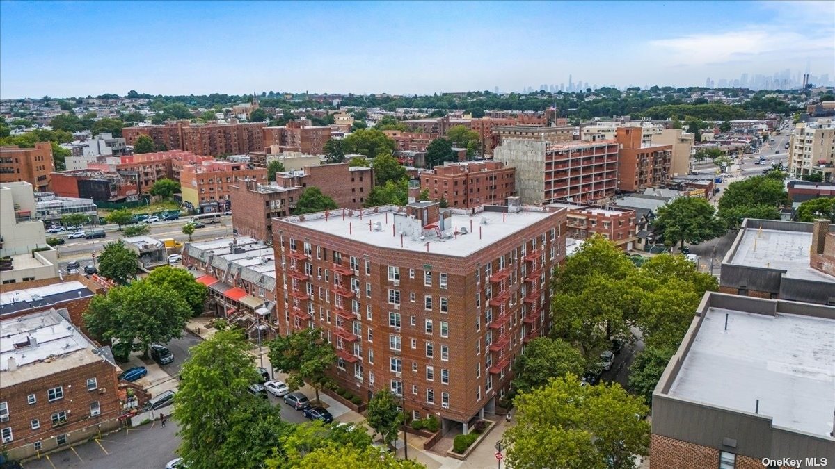 an aerial view of a city with lots of residential buildings ocean and mountain view in back