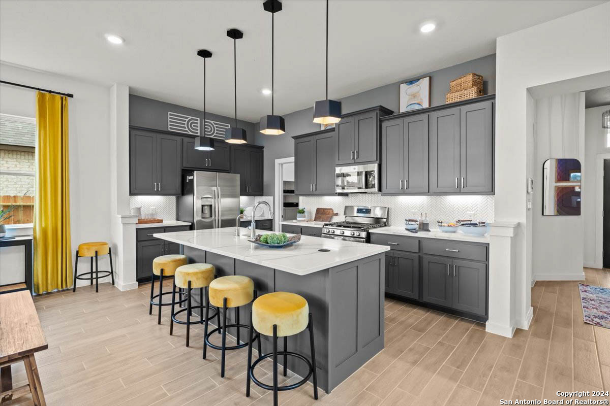 a kitchen with kitchen island granite countertop a sink a center island and stainless steel appliances