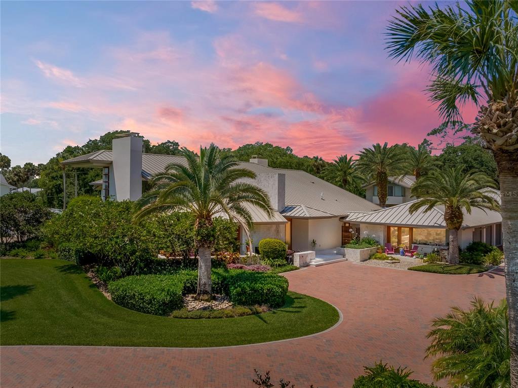 a front view of a house with a yard and palm tree