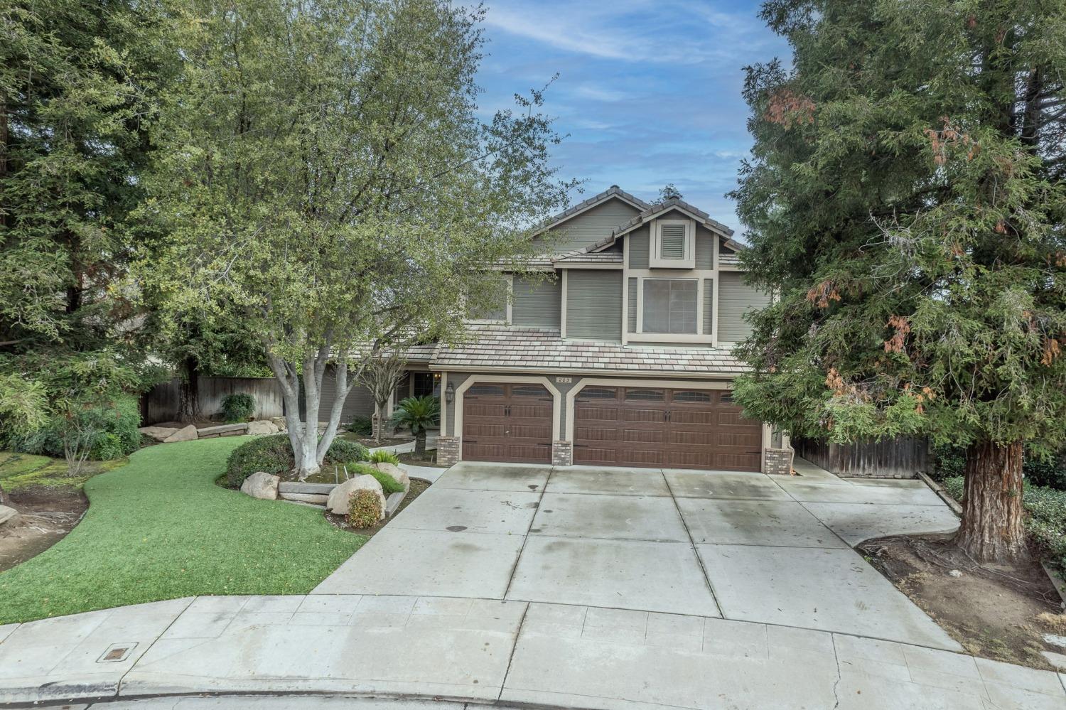 a front view of a house with a yard and trees