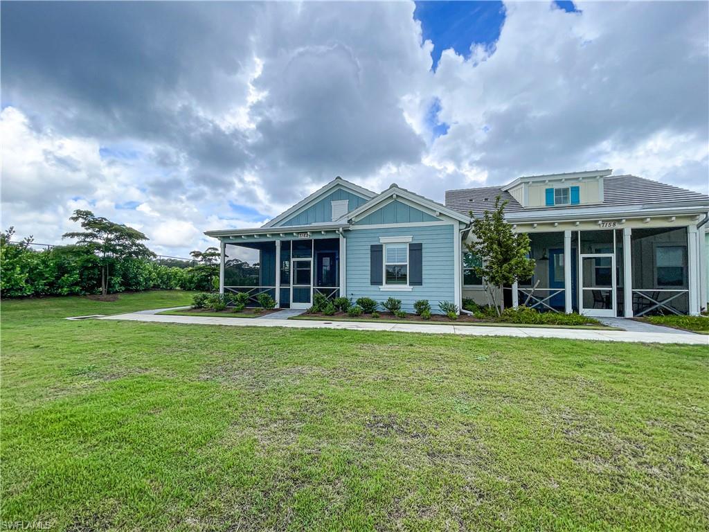 View of front of property featuring a sunroom and a front yard