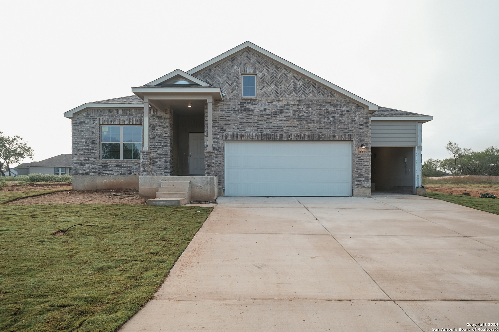 a front view of a house with a garden and garage