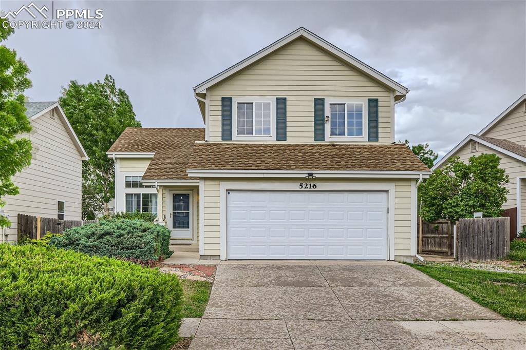 a front view of house with yard and trees around