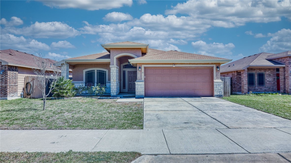 a front view of a house with a yard and garage