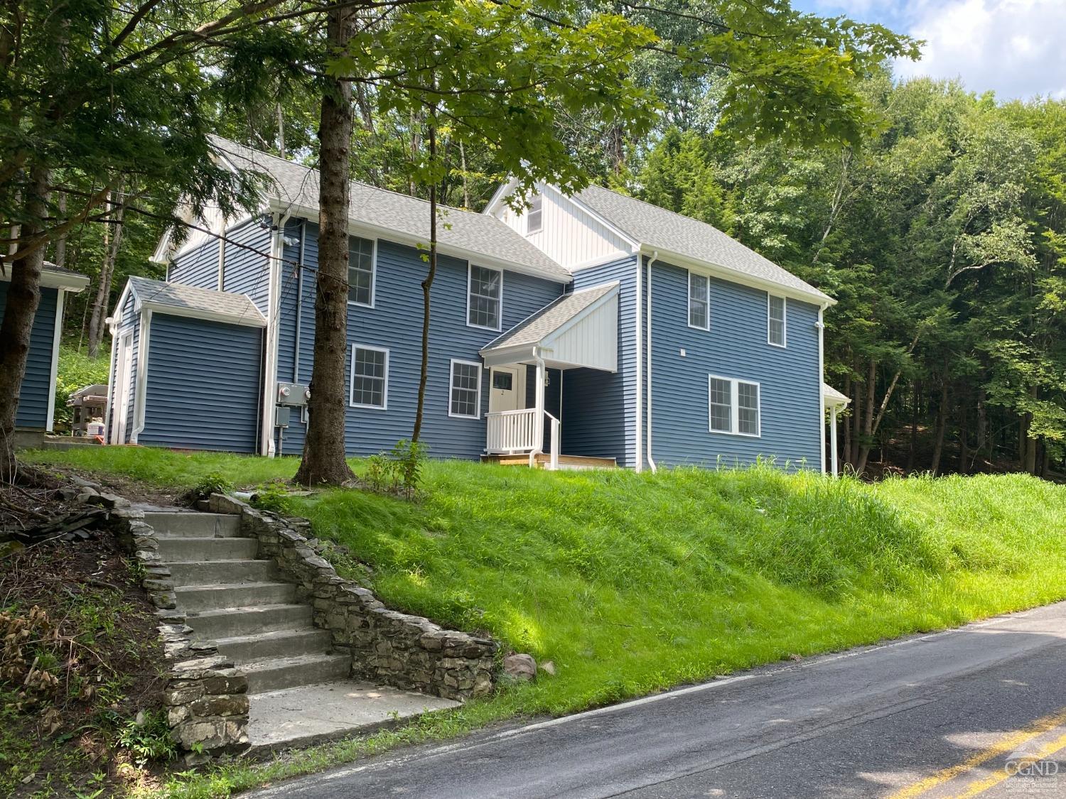 a front view of house with yard and green space