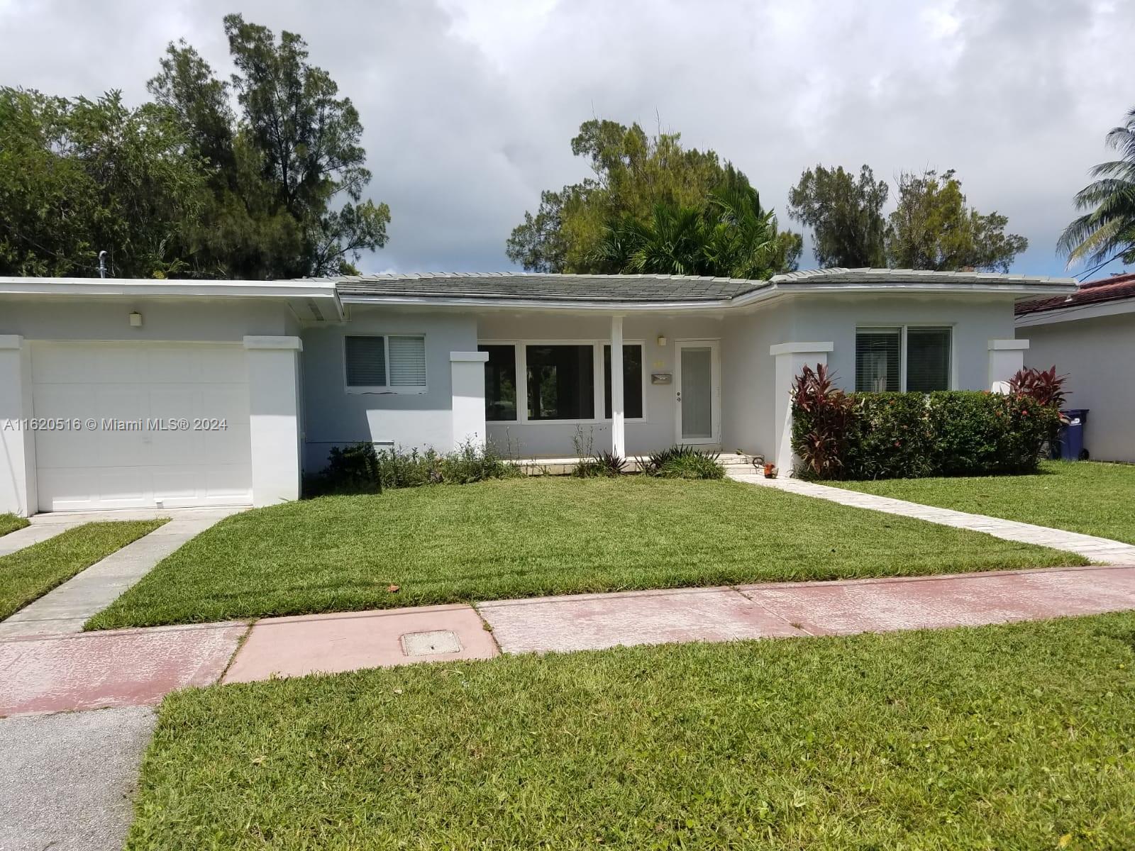 a front view of a house with a garden and yard