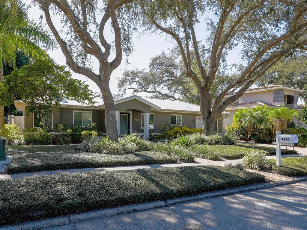 a front view of a house with a yard and potted plants