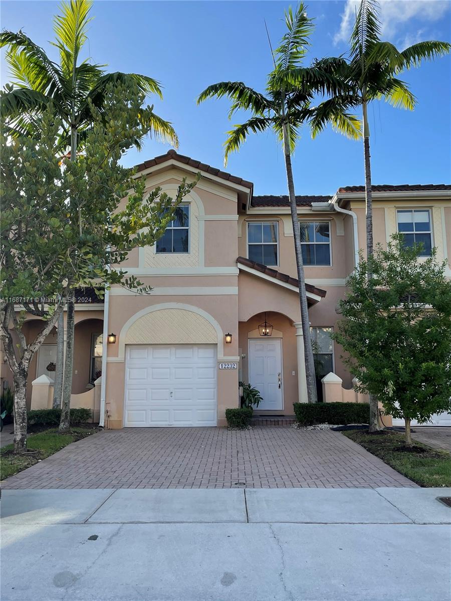 a front view of a house with a garage and a yard