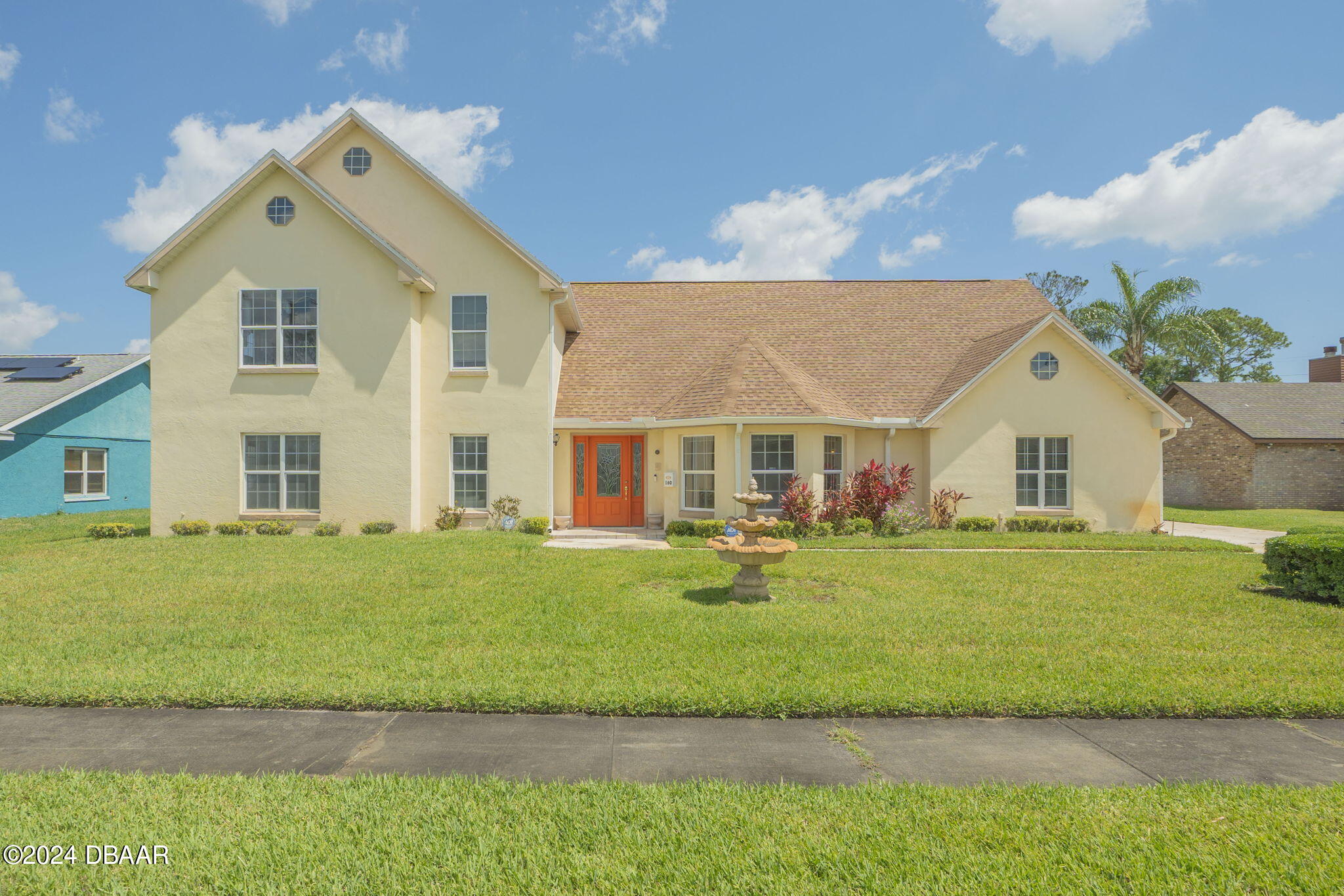 a front view of a house with a garden and yard