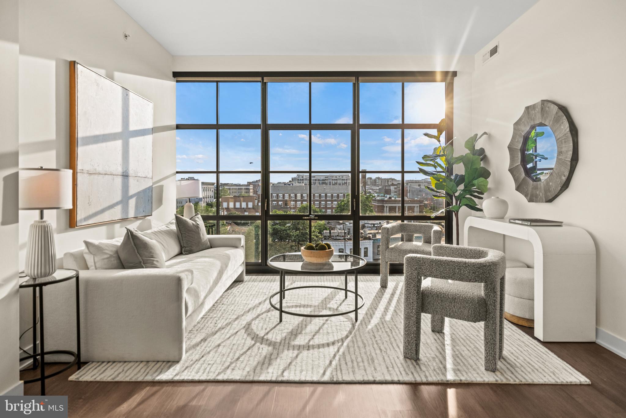 a living room with furniture a window and a floor to ceiling window