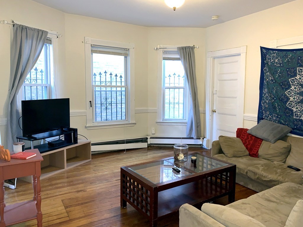 a living room with furniture a flat screen tv and a window