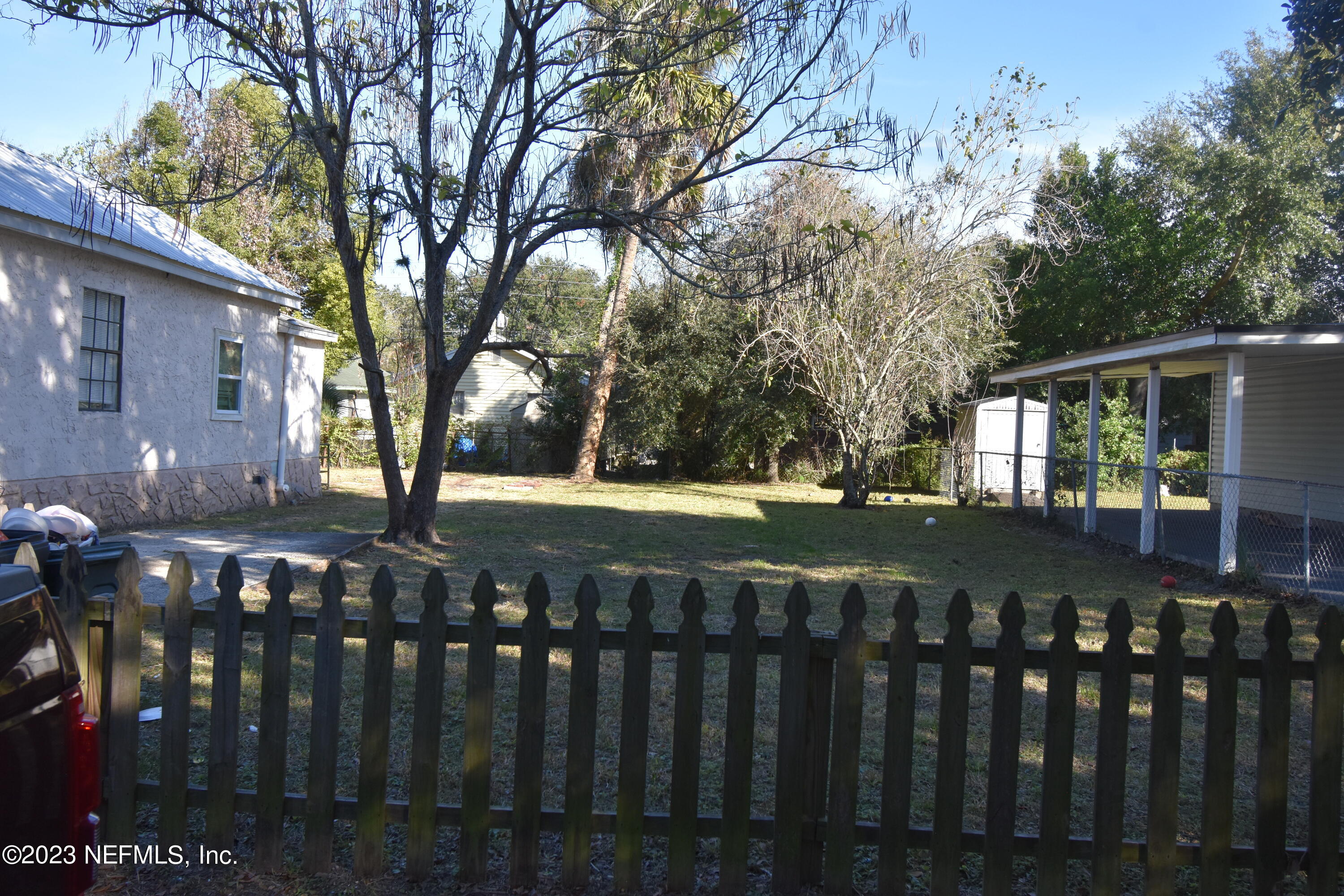 a view of house with yard and wooden fence